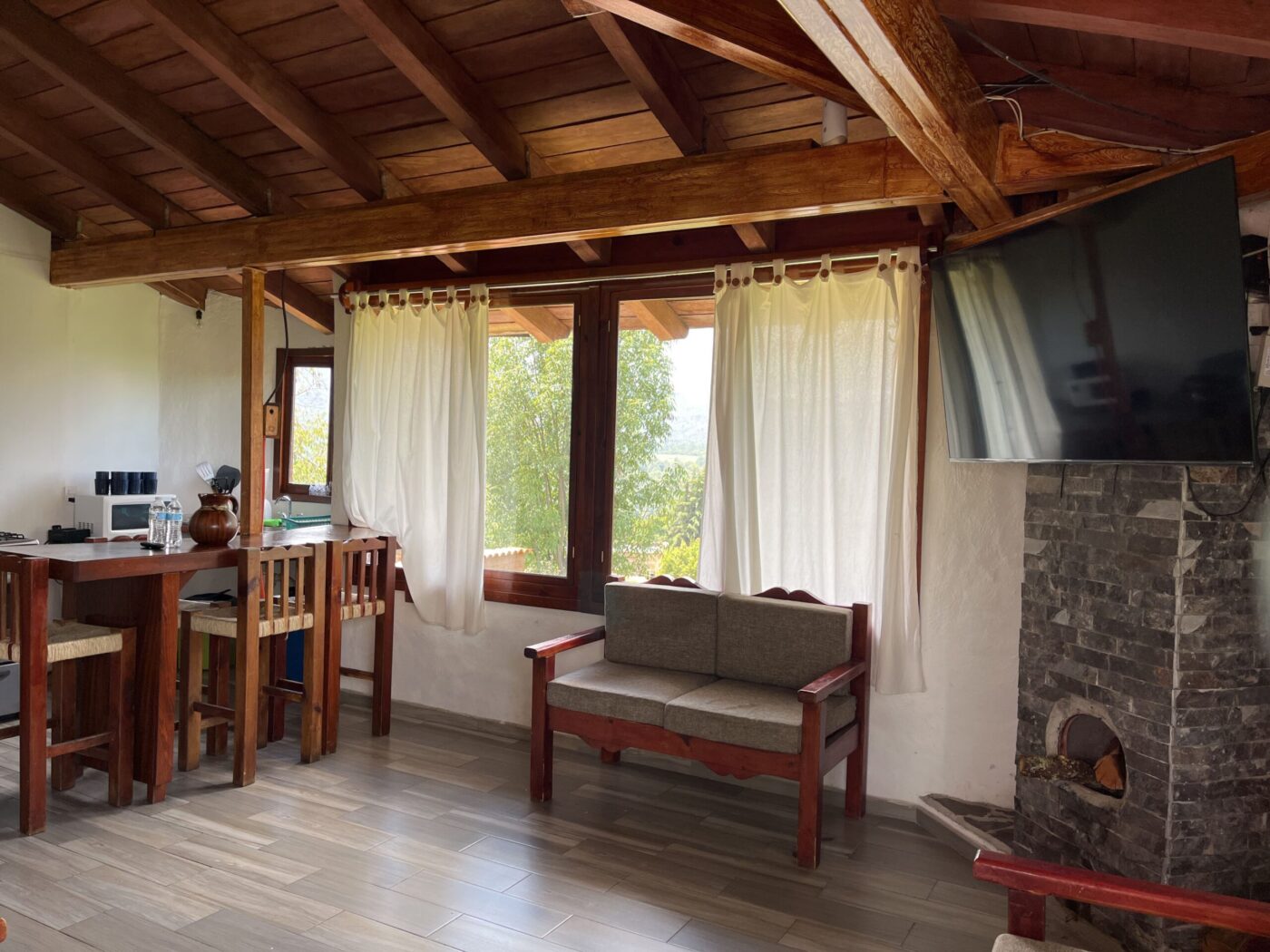 Sala de Villa Manzanos con chimenea y techo de vigas